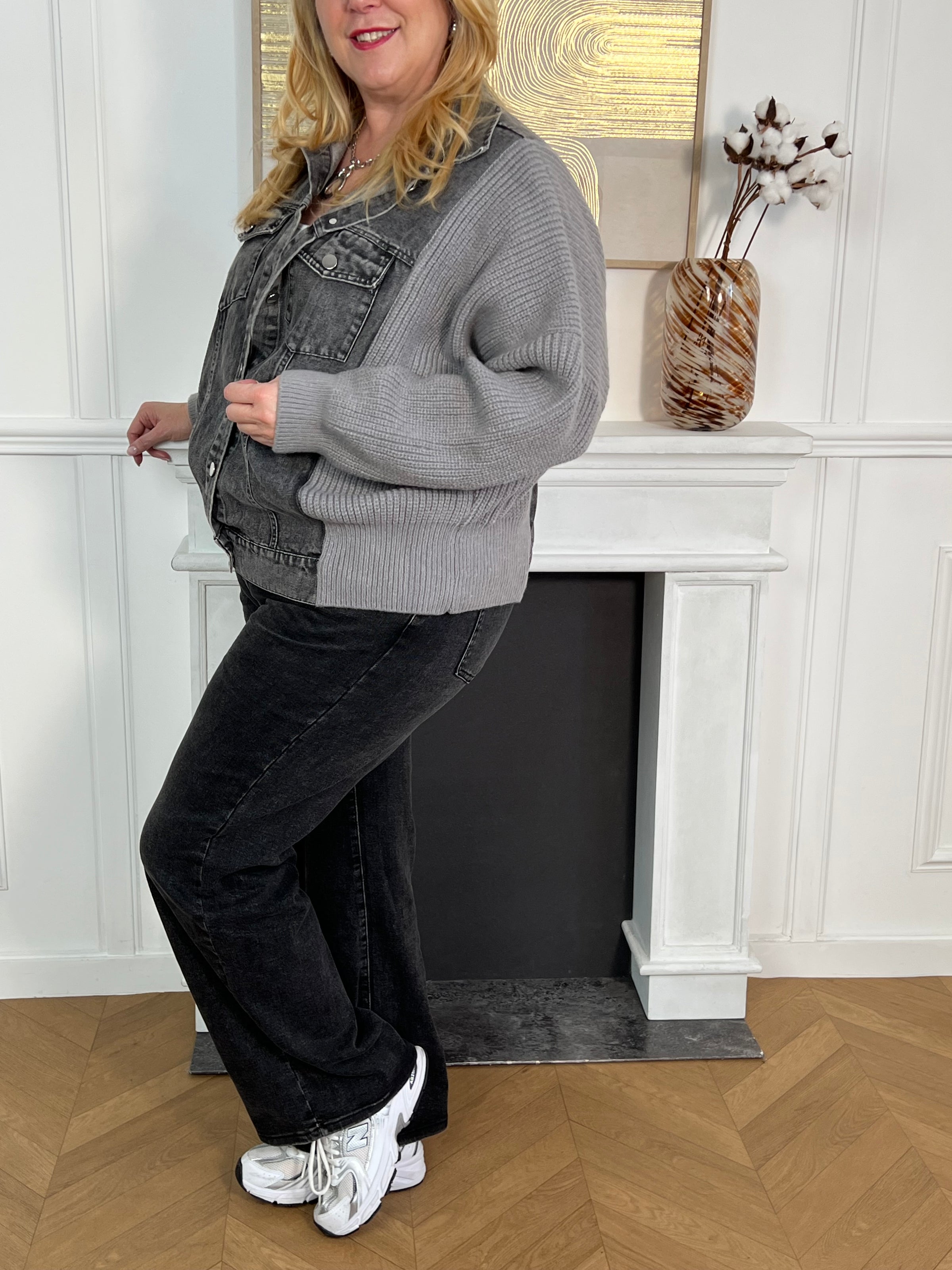 Cette veste grise bi-matière allie l'élégance du jean à la douceur de la maille pour un confort optimal. Dotée d’un col chemise classique, elle se ferme grâce à une rangée de boutons sur le devant et dispose de deux poches avant fermées par boutons, alliant praticité et style.