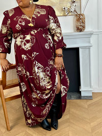 Robe longue bordeaux élégante aux détails dorés grande taille femme, idéale pour les occasions spéciales. Son col V et ses manches longues apportent une touche raffinée, tandis que l’élastique au dos assure un confort parfait. Entièrement doublée jusqu’à mi-longueur, elle allie style et aisance dans des nuances subtiles de bordeaux et doré.