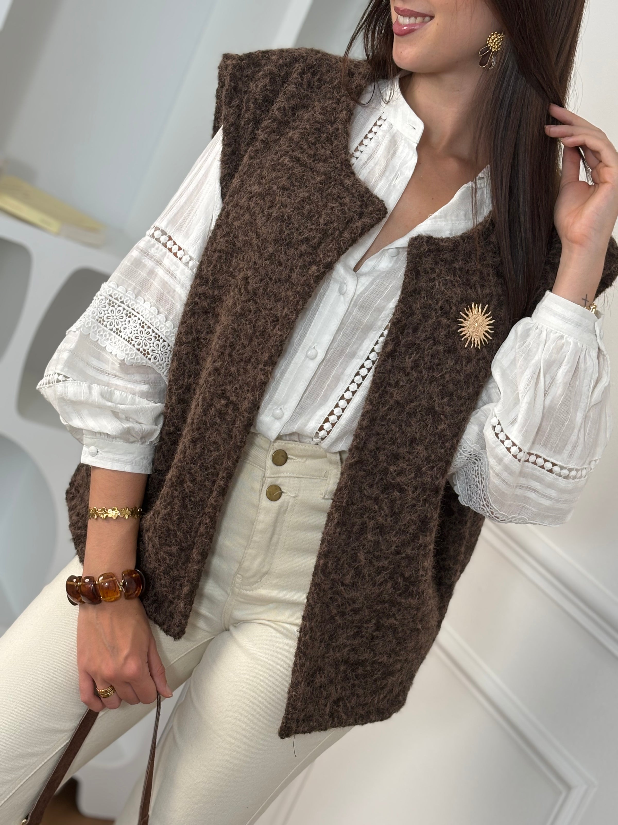 Adoptez l’élégance cosy avec cette veste sans manches marron effet moumoute. Confortable et tendance, elle se porte facilement sur vos tenues pour un look chic et décontracté. Son détail raffiné : une broche dorée amovible, qui apporte une touche lumineuse et personnalisable à votre style.