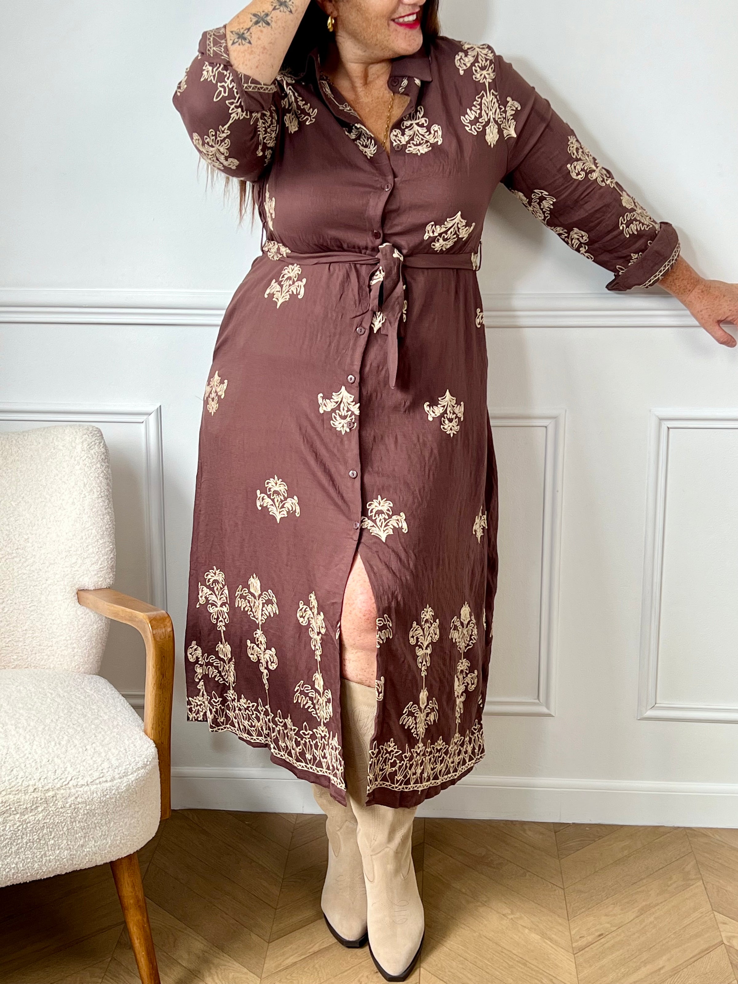 Robe longue marron élégante, mise en valeur par de délicats motifs brodés beiges qui lui apportent charme et raffinement.