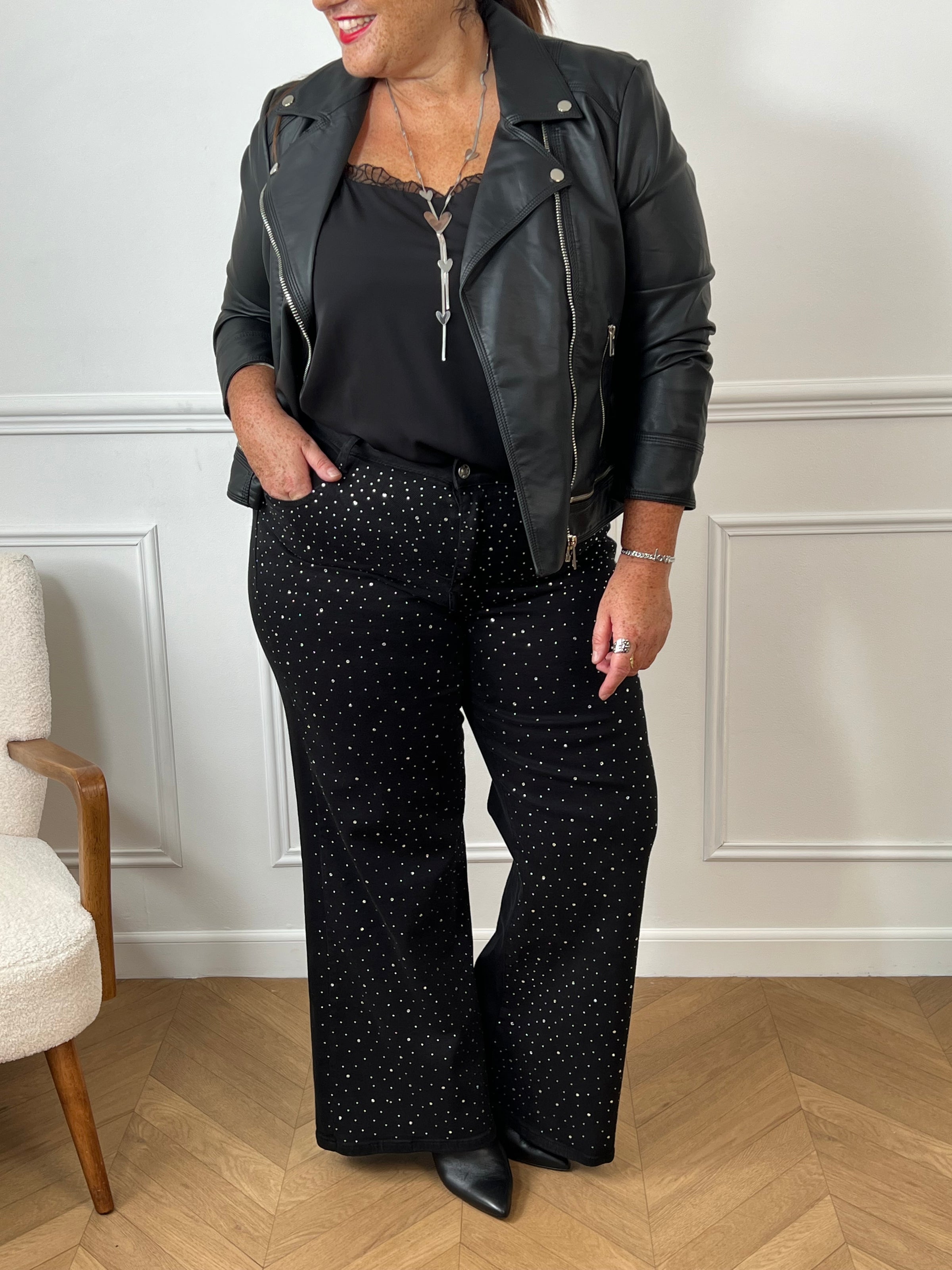 Le jean noir grande taille Romane allie confort et style avec ses deux poches à l’avant et à l’arrière, idéales pour garder l’essentiel à portée de main. Ses passants pour ceinture offrent une tenue ajustée parfaite, tandis que le détail strass sur le devant apporte une touche d’éclat discrète et élégante.