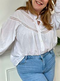 Cette chemise écrue manches longues Angelina est à la fois élégante et pleine d'esprit. Parfaite pour ajouter une touche de fantaisie à votre tenue avec ses boutons et broderies uniques sur le devant et aux manches. La broderie ajourée ajoute une touche de légèreté à cette chemise classique.