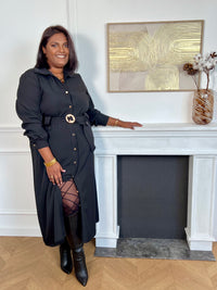 Cette robe longue noire grande taille, Agatha, allie élégance et confort. Dotée de manches longues et d’un col chemise, elle s’ouvre sur une série de boutons dorés tout au long du devant et aux manches, apportant une touche raffinée.