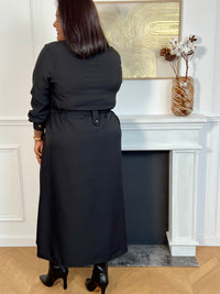 Cette robe longue noire grande taille, Agatha, allie élégance et confort. Dotée de manches longues et d’un col chemise, elle s’ouvre sur une série de boutons dorés tout au long du devant et aux manches, apportant une touche raffinée.