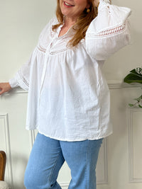 Cette chemise écrue manches longues Angelina est à la fois élégante et pleine d'esprit. Parfaite pour ajouter une touche de fantaisie à votre tenue avec ses boutons et broderies uniques sur le devant et aux manches. La broderie ajourée ajoute une touche de légèreté à cette chemise classique.