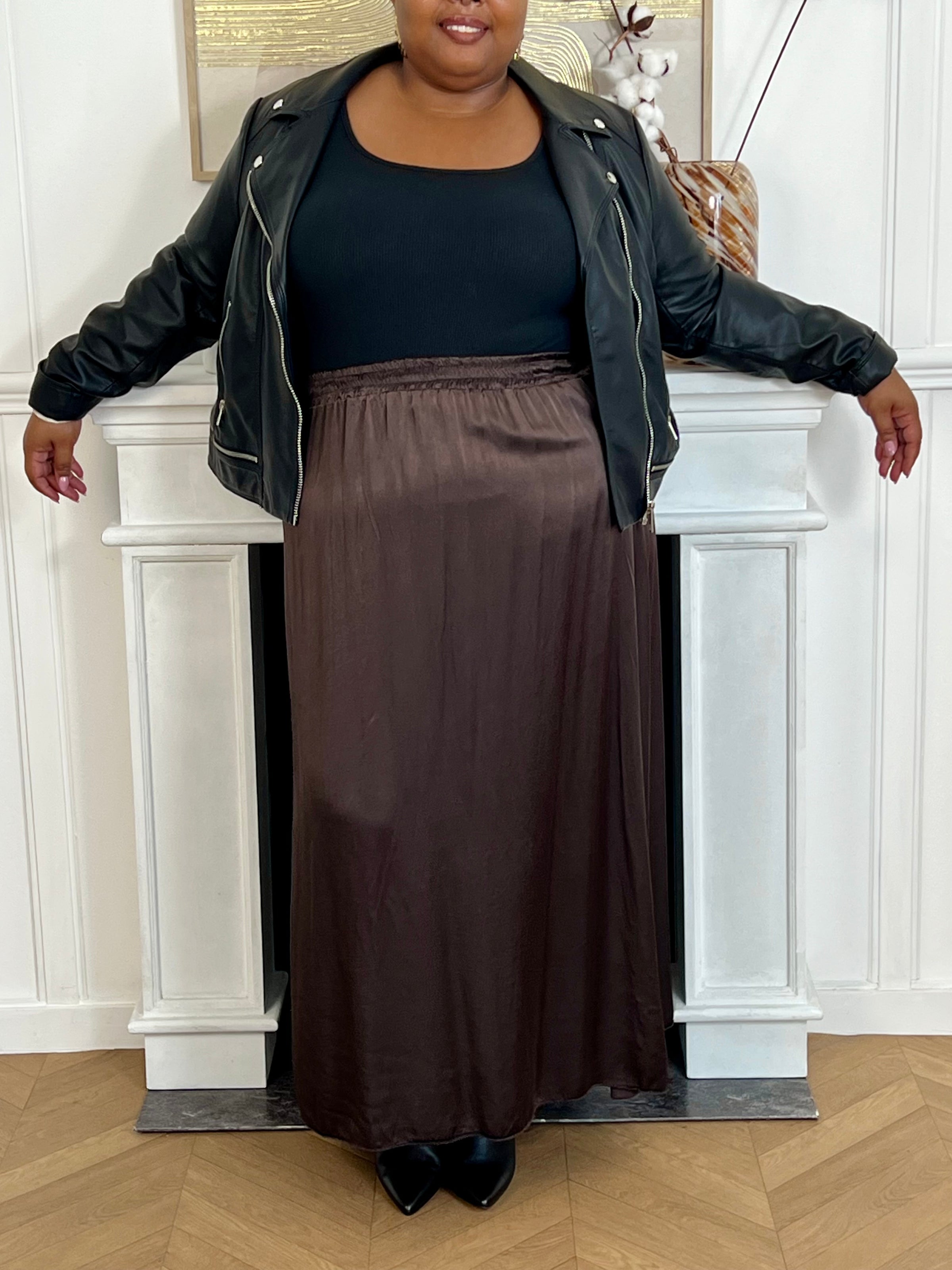 Cette jupe longue en satin marron, modèle Lola, allie élégance et confort grâce à sa taille élastique qui s'adapte parfaitement à toutes les morphologies.