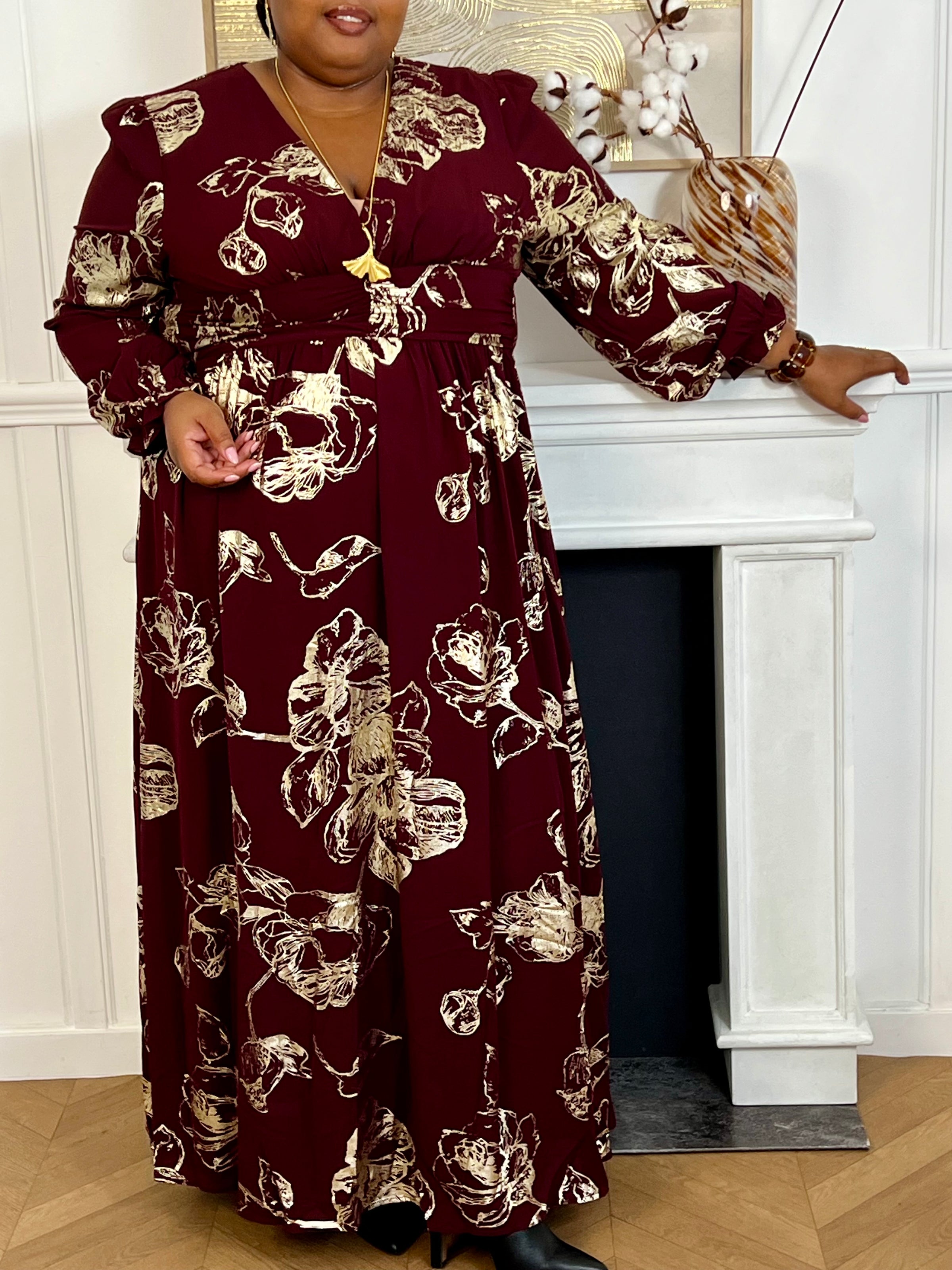 Robe longue bordeaux élégante aux détails dorés grande taille femme, idéale pour les occasions spéciales. Son col V et ses manches longues apportent une touche raffinée, tandis que l’élastique au dos assure un confort parfait. Entièrement doublée jusqu’à mi-longueur, elle allie style et aisance dans des nuances subtiles de bordeaux et doré.