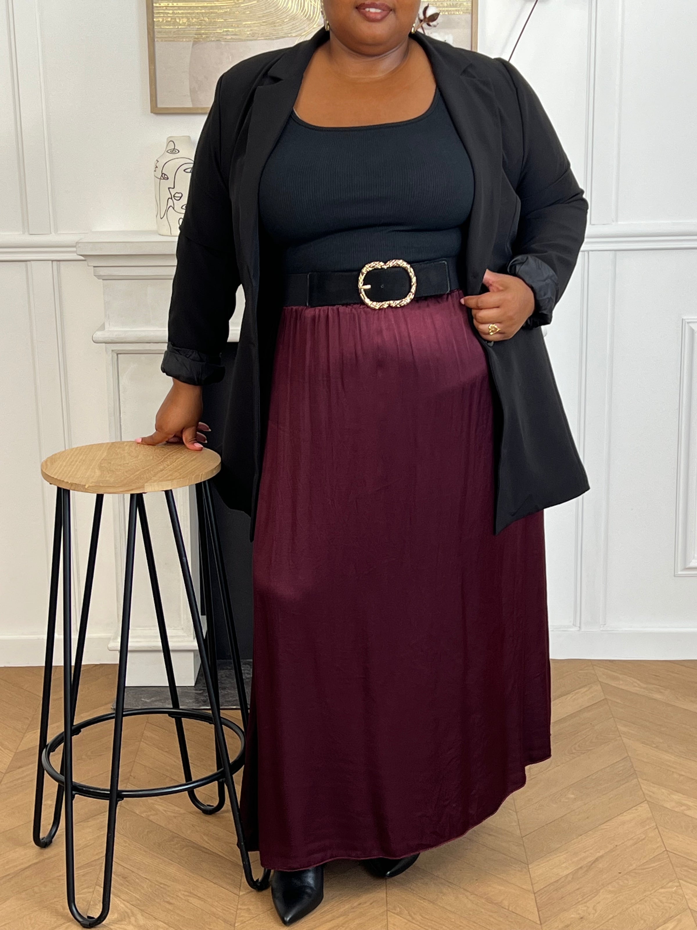 Cette jupe longue en satin bordeaux, modèle Lola, allie élégance et confort grâce à sa taille élastique qui s'adapte parfaitement à toutes les morphologies.