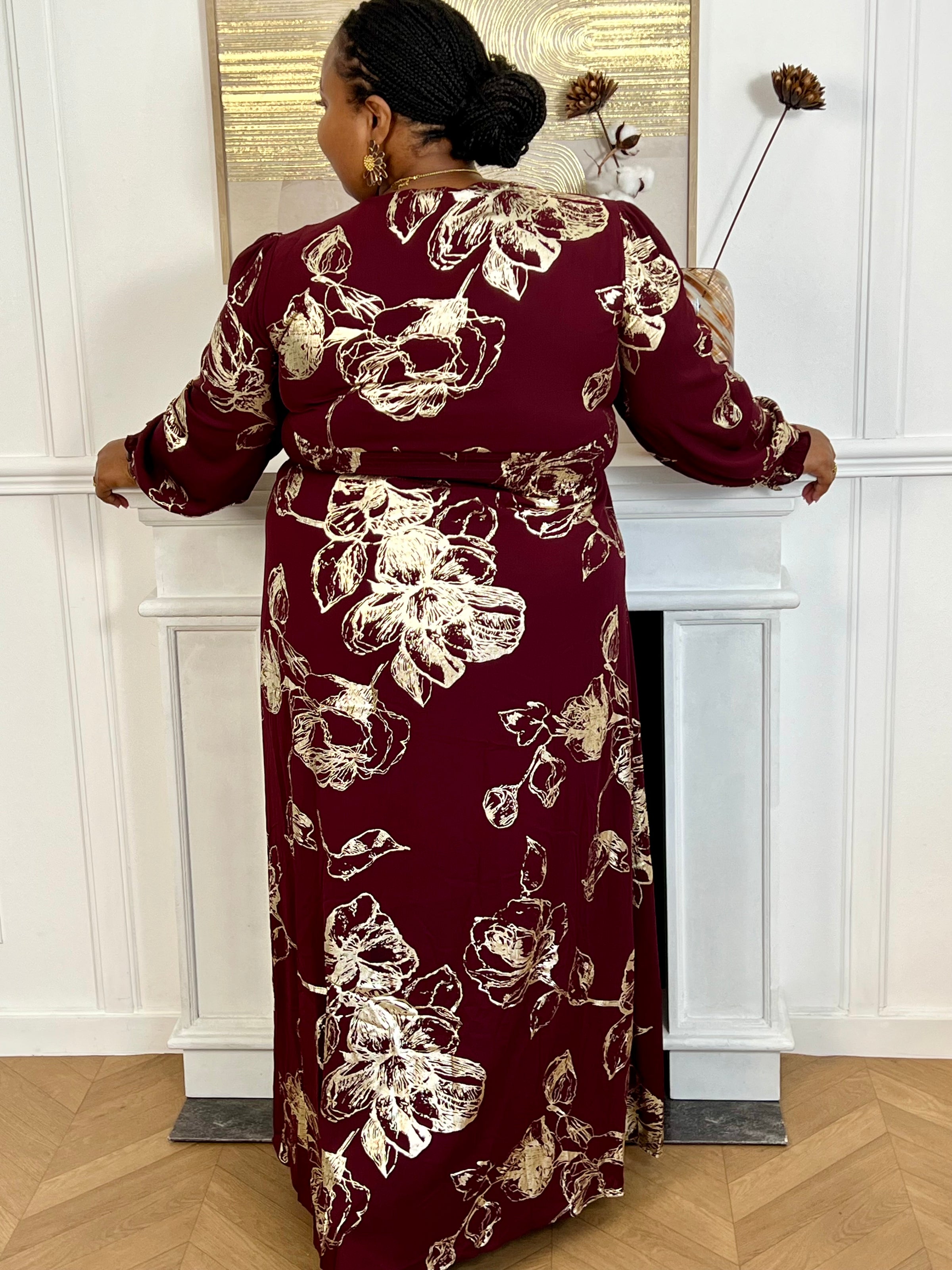 Robe longue bordeaux élégante aux détails dorés grande taille femme, idéale pour les occasions spéciales. Son col V et ses manches longues apportent une touche raffinée, tandis que l’élastique au dos assure un confort parfait. Entièrement doublée jusqu’à mi-longueur, elle allie style et aisance dans des nuances subtiles de bordeaux et doré.