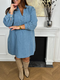Cette robe courte en jean bleu clair séduit par sa coupe ample et son col V à revers. Dotée de manches longues, de poches pratiques et de détails dorés aux poignets, elle allie confort et style au quotidien.