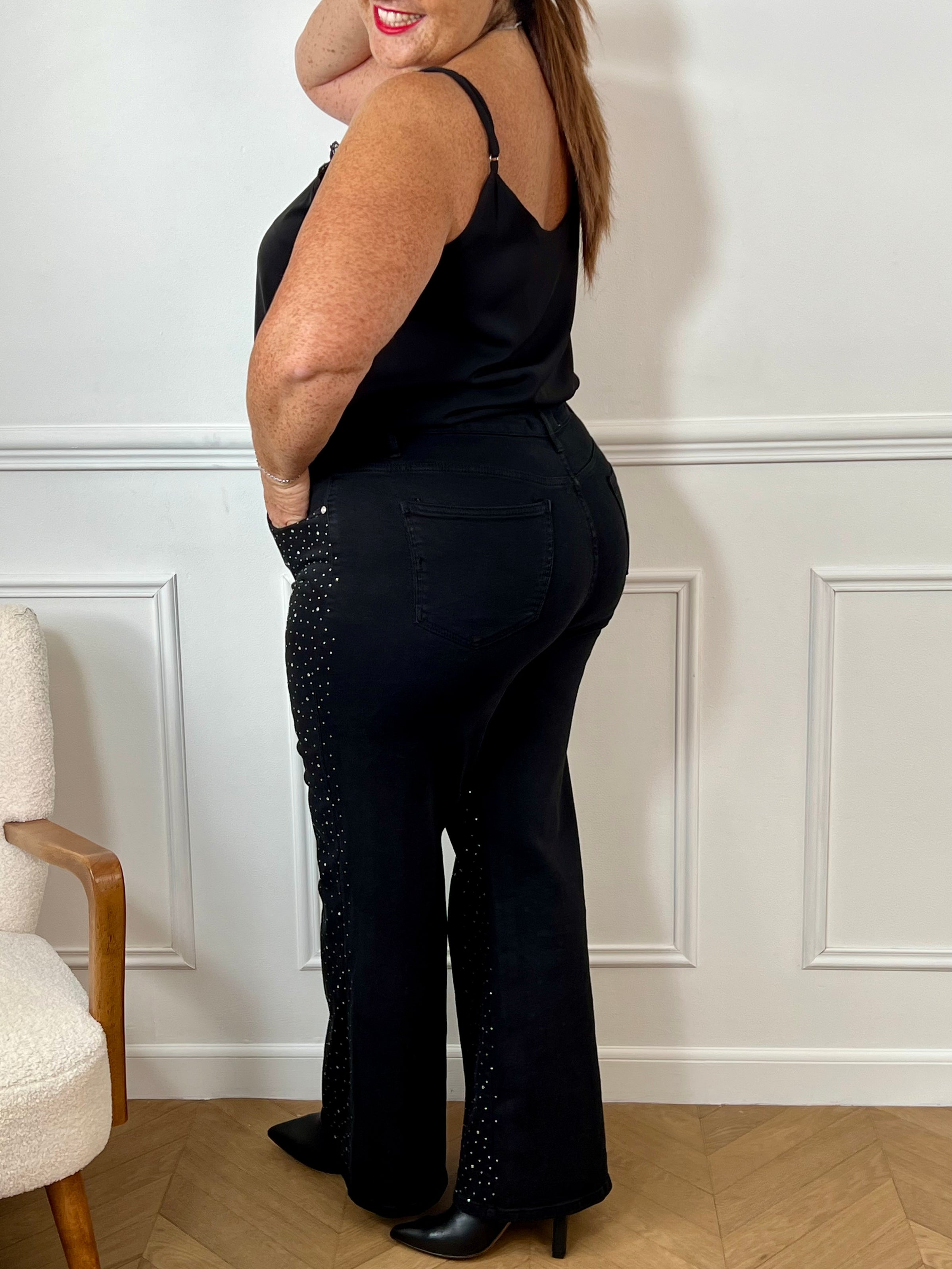 Le jean noir grande taille Romane allie confort et style avec ses deux poches à l’avant et à l’arrière, idéales pour garder l’essentiel à portée de main. Ses passants pour ceinture offrent une tenue ajustée parfaite, tandis que le détail strass sur le devant apporte une touche d’éclat discrète et élégante.
