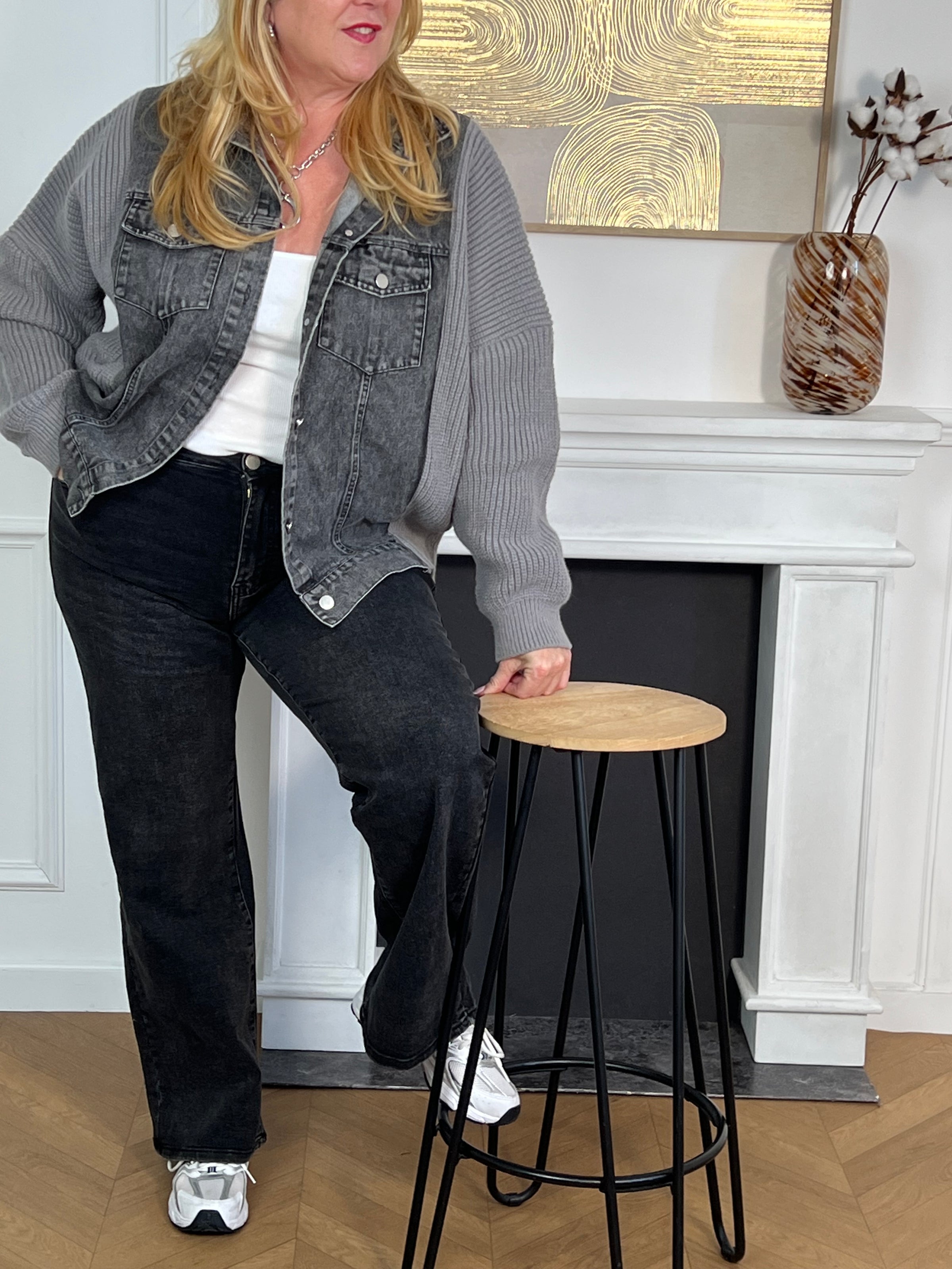 Cette veste grise bi-matière allie l'élégance du jean à la douceur de la maille pour un confort optimal. Dotée d’un col chemise classique, elle se ferme grâce à une rangée de boutons sur le devant et dispose de deux poches avant fermées par boutons, alliant praticité et style.