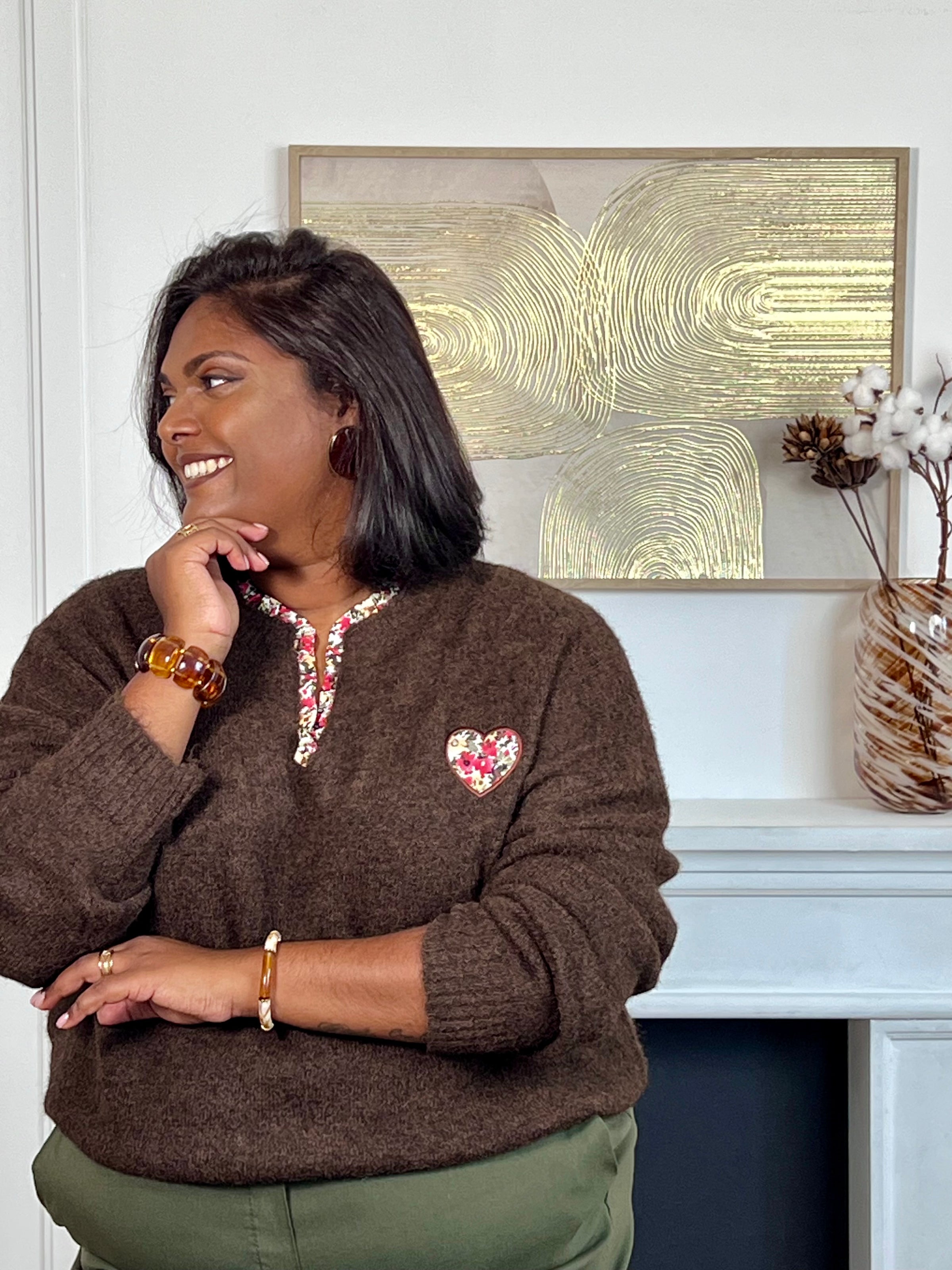 Ce pull marron grande taille allie douceur et élégance avec ses manches longues et son col en V orné de délicats motifs floraux. Un coeur brodé vient sublimer le devant, apportant une touche unique et féminine