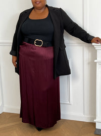 Cette jupe longue en satin bordeaux, modèle Lola, allie élégance et confort grâce à sa taille élastique qui s'adapte parfaitement à toutes les morphologies.