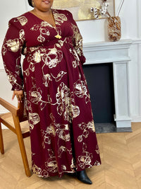 Robe longue bordeaux élégante aux détails dorés grande taille femme, idéale pour les occasions spéciales. Son col V et ses manches longues apportent une touche raffinée, tandis que l’élastique au dos assure un confort parfait. Entièrement doublée jusqu’à mi-longueur, elle allie style et aisance dans des nuances subtiles de bordeaux et doré.