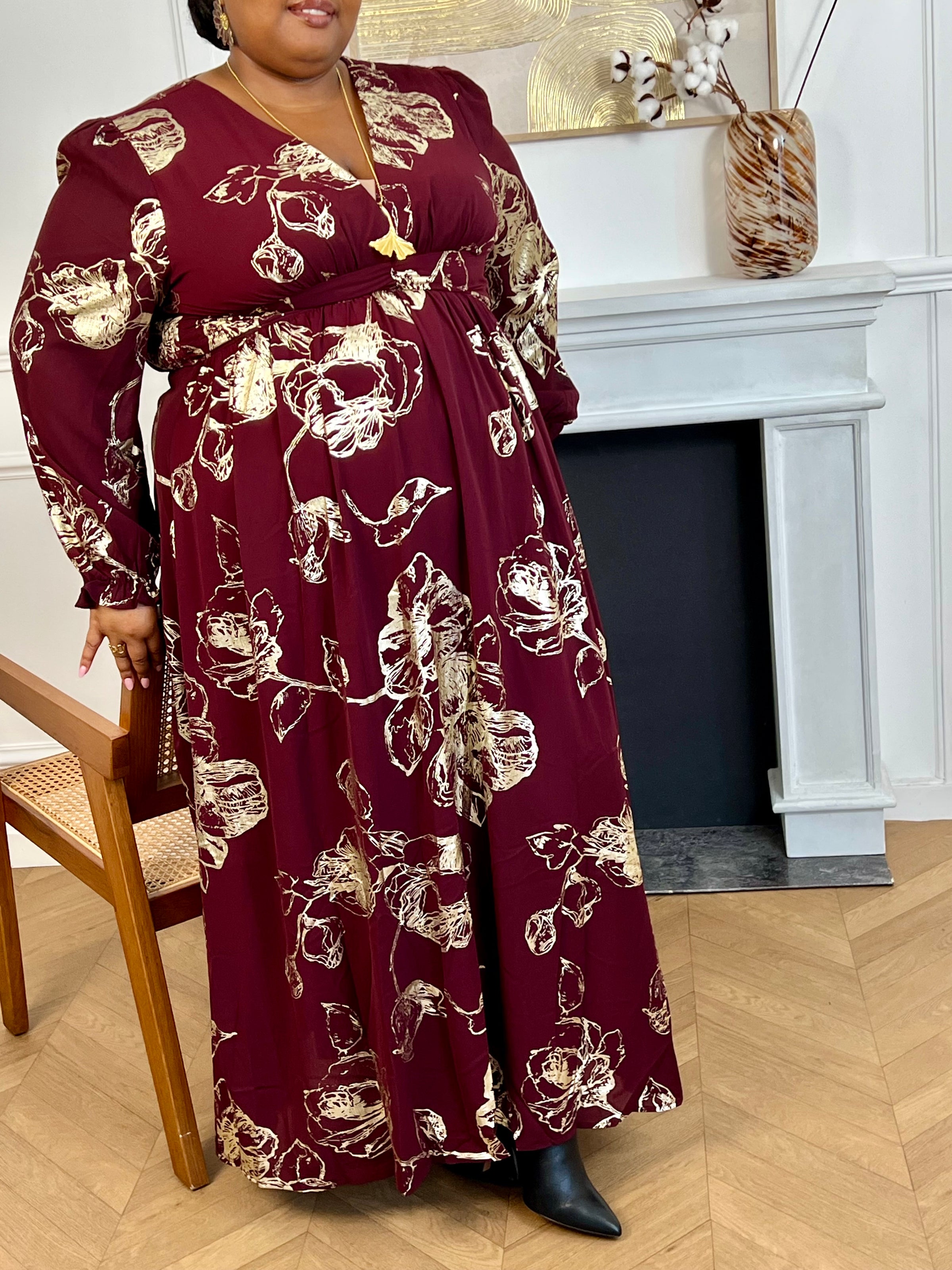 Robe longue bordeaux élégante aux détails dorés grande taille femme, idéale pour les occasions spéciales. Son col V et ses manches longues apportent une touche raffinée, tandis que l’élastique au dos assure un confort parfait. Entièrement doublée jusqu’à mi-longueur, elle allie style et aisance dans des nuances subtiles de bordeaux et doré.