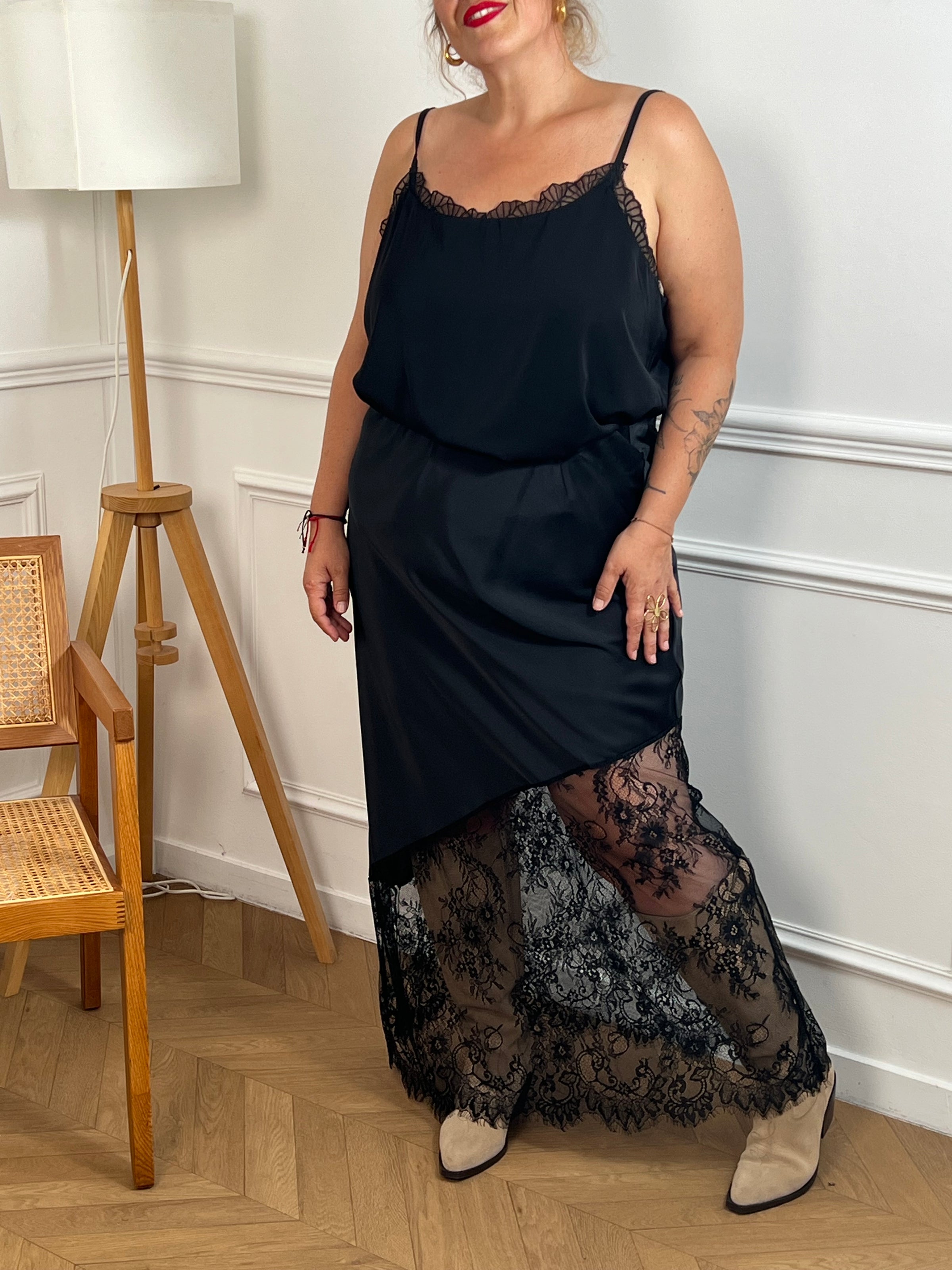 Cette jupe longue noire grande taille est conçue pour allier confort et élégance. Sa taille élastique assure un ajustement parfait, tandis que la dentelle ajourée sur le bas apporte une touche délicate et féminine.