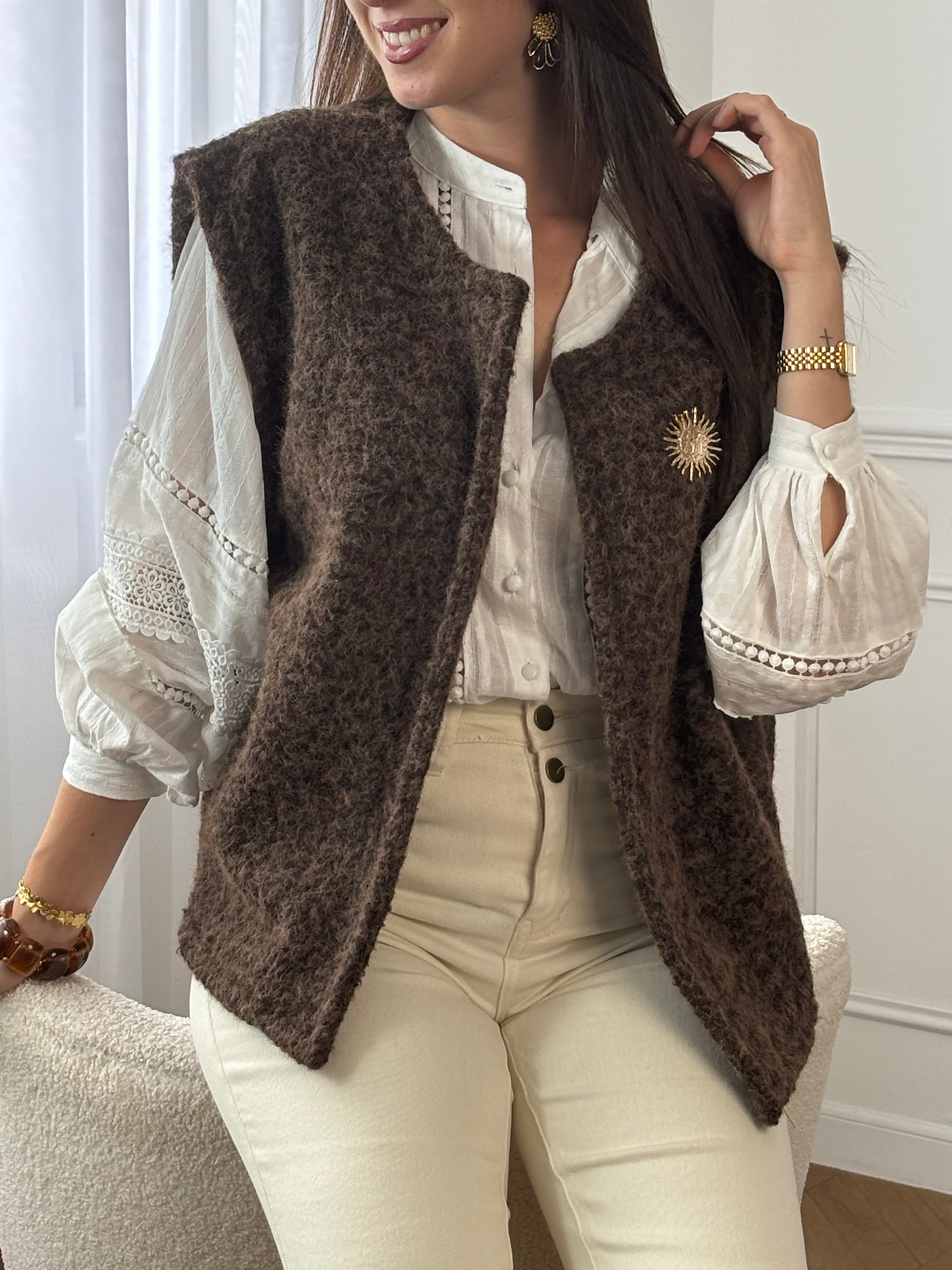 Adoptez l’élégance cosy avec cette veste sans manches marron effet moumoute. Confortable et tendance, elle se porte facilement sur vos tenues pour un look chic et décontracté. Son détail raffiné : une broche dorée amovible, qui apporte une touche lumineuse et personnalisable à votre style.