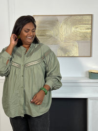 Cette chemise kaki manches longues Angelina est à la fois élégante et pleine d'esprit. Parfaite pour ajouter une touche de fantaisie à votre tenue avec ses boutons et broderies uniques sur le devant et aux manches.