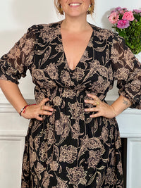 Cette robe longue à motifs Lyvia offre un confort parfait grâce à sa taille et ses poignets élastiques qui épousent délicatement toutes les silhouettes. Son col cache-cœur met en valeur le décolleté tandis que ses manches longues apportent une élégance intemporelle.