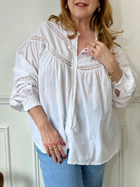 Cette chemise écrue manches longues Angelina est à la fois élégante et pleine d'esprit. Parfaite pour ajouter une touche de fantaisie à votre tenue avec ses boutons et broderies uniques sur le devant et aux manches. La broderie ajourée ajoute une touche de légèreté à cette chemise classique.