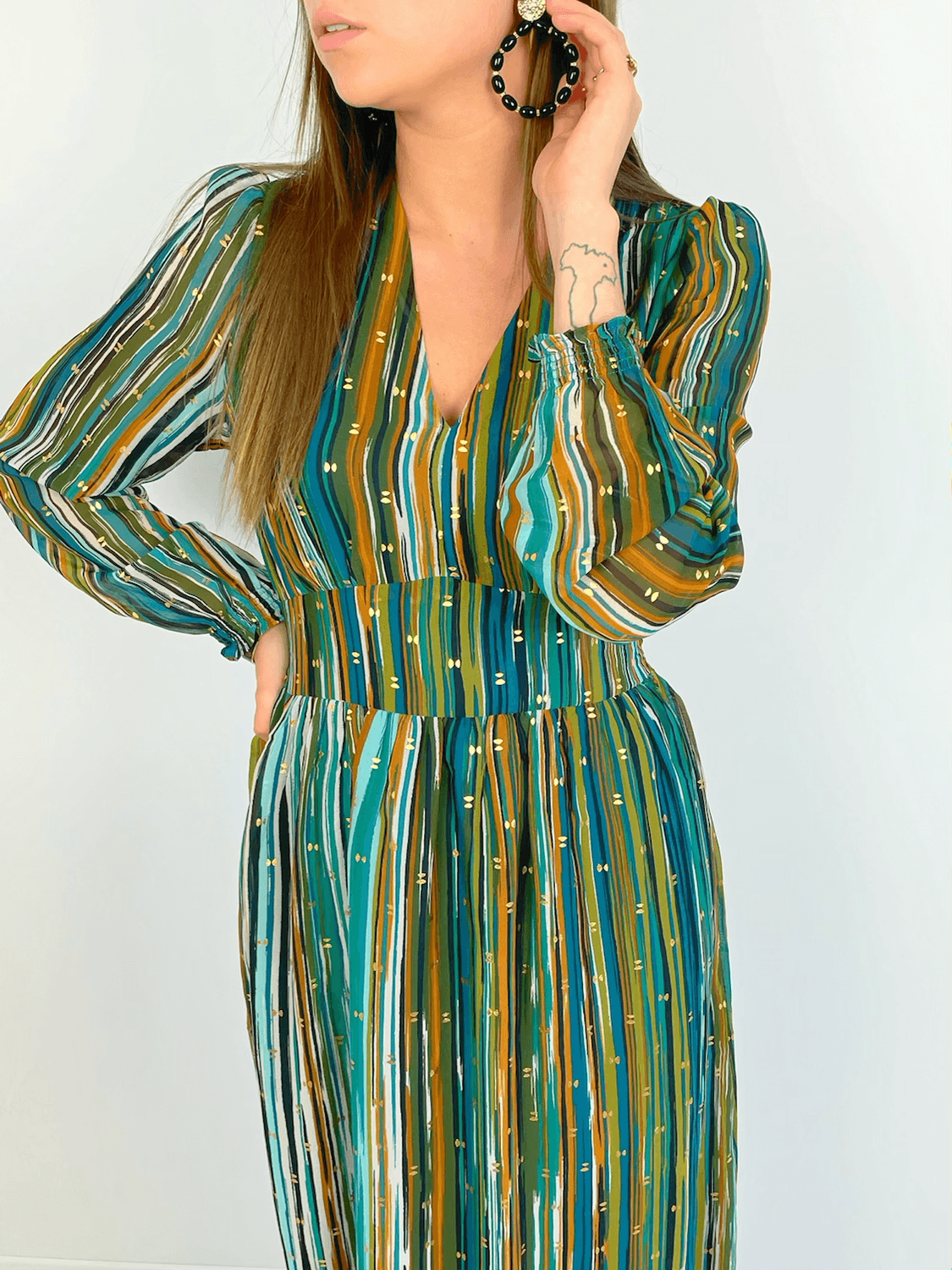 ROBE COLORÉE ET LONGUE Robe longue Col V Elastiqué à la taille Manches transparentes Motif doré sur fond nuancé vert, bleu, marron, noir et blanc Composition: 100% Polyester Lavage à la main