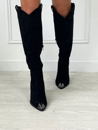 BOTTES SANTIAG NOIR DÉTAILS ARGENTÉ Bottes hautes type santiags Détail brillant sur le bout de la botte L’ouverture s’effectue sur le zip intérieur Taille normalement Couleur : noir Effet daim 100% Synthétique