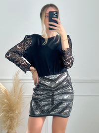 JUPE NOIRE ET ARGENTÉE COURTE Jupe courte Fermeture éclair sur le côté Couleur : noir avec paillettes argentées Composition : 95% Polyester 5% Elasthanne Entretien et Lavage : Main conseillée