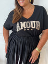 Adoptez le confort avec ce tee-shirt grande taille noir, orné d’une inscription "Amour". Ses manches courtes et son col rond offrent une coupe agréable qui s’adapte parfaitement à votre silhouette.