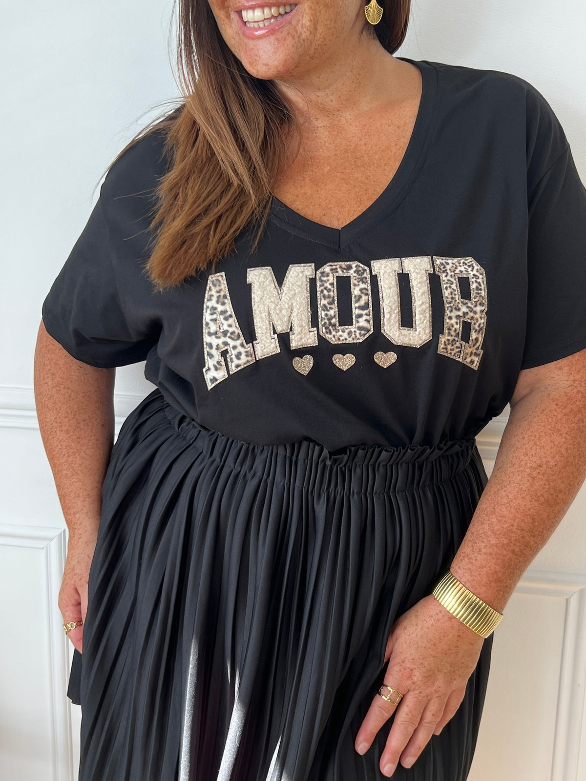 Adoptez le confort avec ce tee-shirt grande taille noir, orné d’une inscription "Amour". Ses manches courtes et son col rond offrent une coupe agréable qui s’adapte parfaitement à votre silhouette.