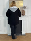Chic et pratique, ce manteau noir à manches longues séduit par sa capuche amovible effet sweat gris. Une pièce moderne et polyvalente qui offre à la fois chaleur, confort et élégance au quotidien.