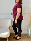 Tee-shirt bordeaux grande taille pour femme, manches courtes et col V élégant. Sa coupe moderne plus longue à l’arrière offre confort et style. Détail chic : inscription dorée "Love". Couleurs tendance bordeaux et doré, idéal pour un look casual et féminin