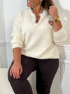 Ce pull beige grande taille allie douceur et élégance avec ses manches longues et son col en V orné de délicats motifs floraux. Un coeur brodé vient sublimer le devant, apportant une touche unique et féminine
