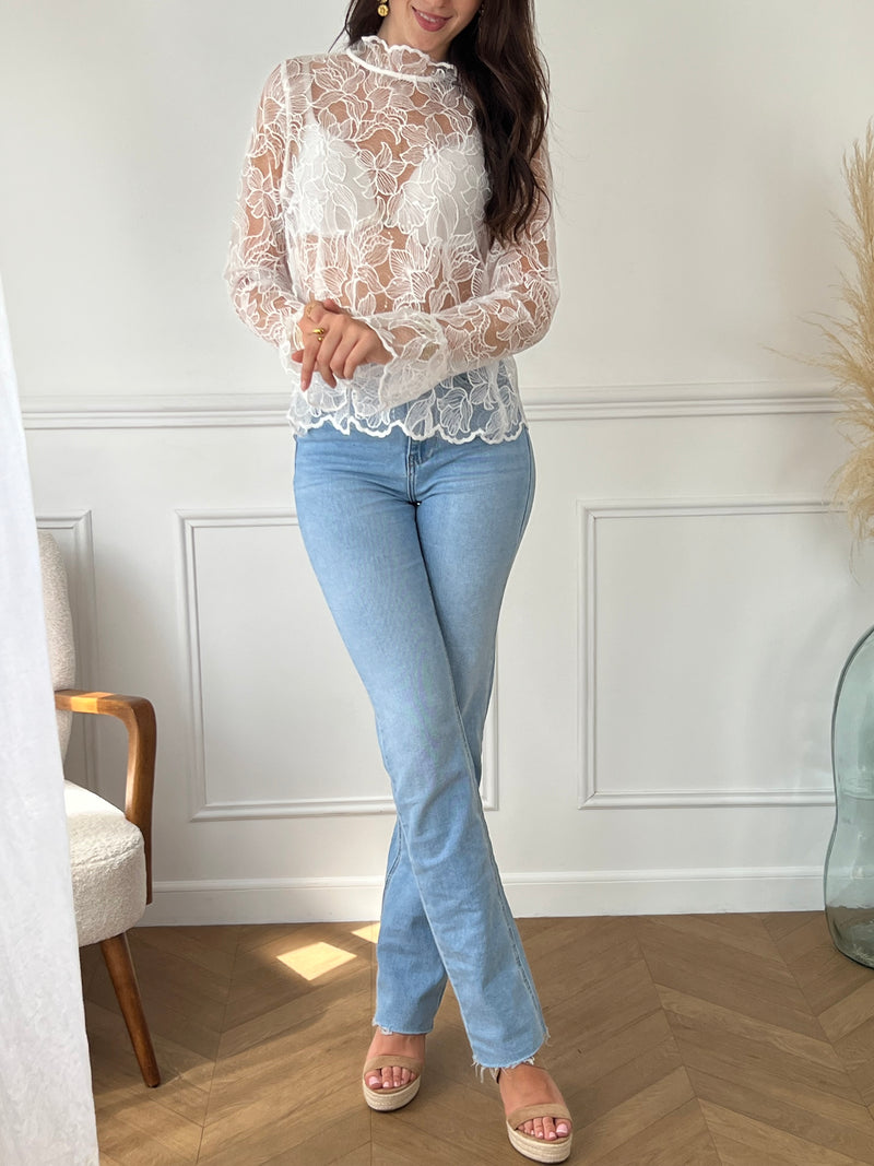 Cette blouse écrue Evelina allie délicatesse et élégance. Confectionnée en broderie ajourée, elle offre une touche de légèreté et de fraîcheur. Son col rond orné de volants apporte une note féminine raffinée, tandis que les deux boutons sur le devant facilitent l’enfilage.