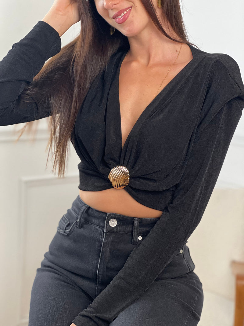 Ce top manches longues noir Debora allie élégance et confort grâce à sa matière fluide qui épouse délicatement la silhouette. Son ornement doré central apporte une touche sophistiquée, tandis que les manches légèrement ajourées offrent subtilité et légèreté.