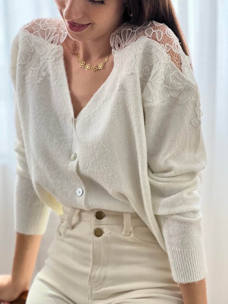 Un gilet tout en délicatesse… Cet élégant gilet écru se distingue par sa broderie raffinée sur les épaules, laissant subtilement apparaître la peau pour un effet de transparence à la fois chic et féminin. Un indispensable pour allier douceur et élégance en toute saison.