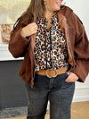 Chemise fluide à motif léopard, ajourée sur le devant et aux manches pour une touche élégante et moderne. Son col montant et ses manches longues lui confèrent une allure chic, idéale pour toutes les occasions. Ses nuances de marron, beige et noir s’accordent facilement pour un style à la fois tendance et raffiné.