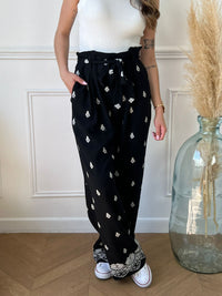 Découvrez notre pantalon en lin noir, rehaussé de motifs écru élégants. Parfait pour les journées ensoleillées et les soirées estivales grâce à sa couleur, il allie confort et style.