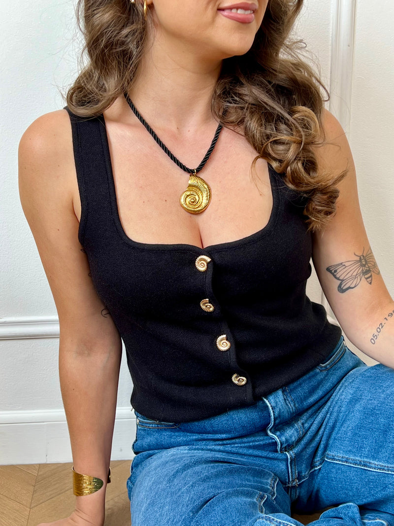 Gilet sans manches au charme vintage, doté d’un col carré structuré et rehaussé de boutons dorés en forme de coquillage. Une pièce délicate et originale, parfaite pour apporter une touche de caractère à vos tenues.