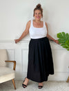 La jupe noire plissée de grande taille incarne une élégance intemporelle. Avec sa coupe longue, elle offre une silhouette flatteuse et tendance. Cette pièce allie style et confort, créant une tenue sophistiquée et moderne pour les femmes de grande taille.