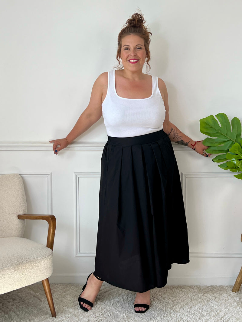 La jupe noire plissée de grande taille incarne une élégance intemporelle. Avec sa coupe longue, elle offre une silhouette flatteuse et tendance. Cette pièce allie style et confort, créant une tenue sophistiquée et moderne pour les femmes de grande taille.