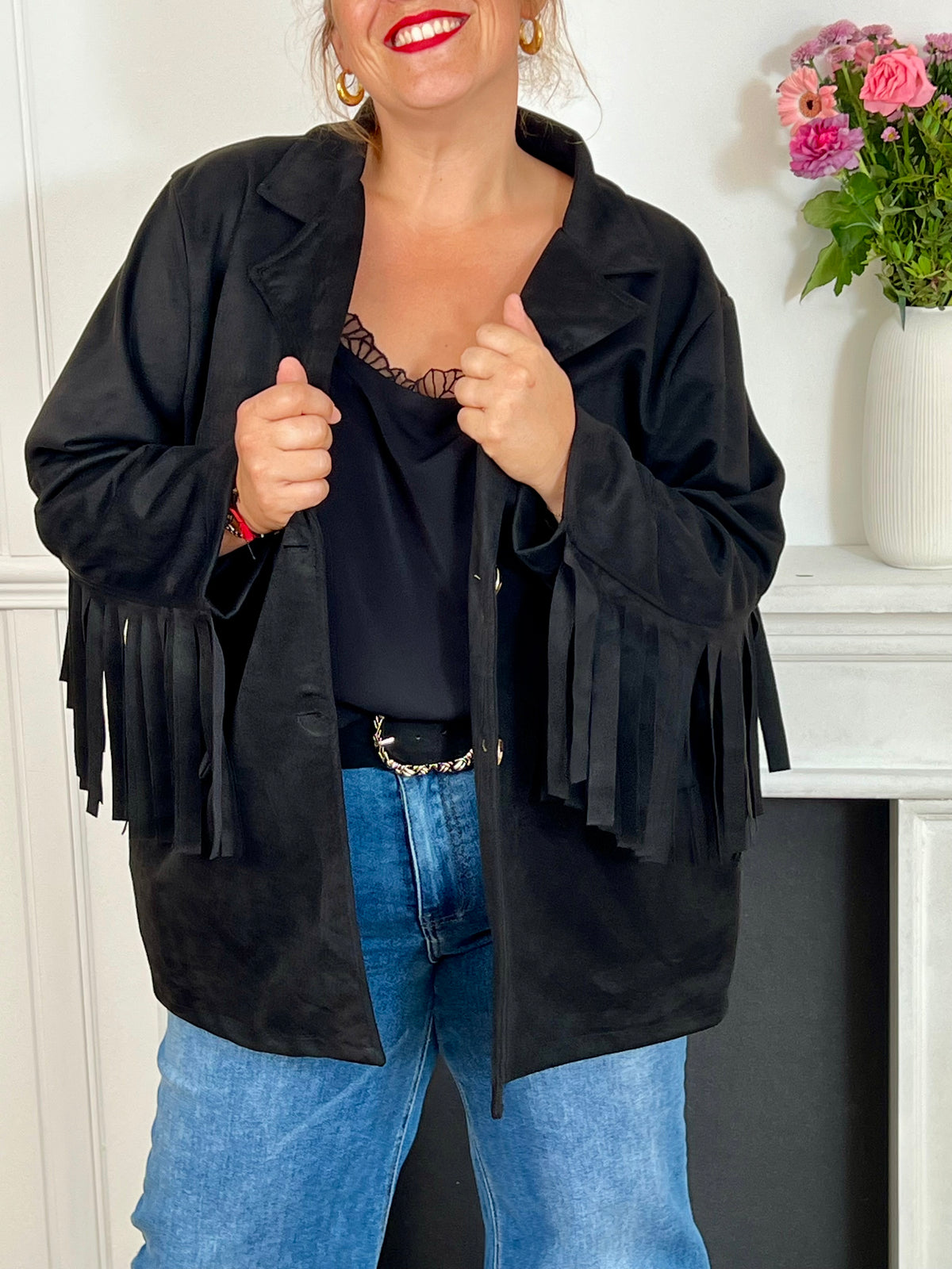 Cette veste noir en effet daim, ornée de franges au dos et aux manches, offre un style unique. Ses manches longues et ses poches latérales pratiques allient élégance et confort, idéale pour les grandes tailles.