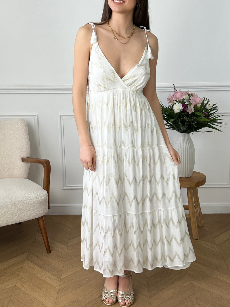 Rehaussez votre garde-robe avec notre robe longue bohème écrue Florida ! Avec ses détails dorés et ses bretelles fines, cette robe vous apportera élégance et style. Idéale pour les journées chaudes d'été ou les soirées estivales, vous vous sentirez belle et à l'aise dans cette robe longue.