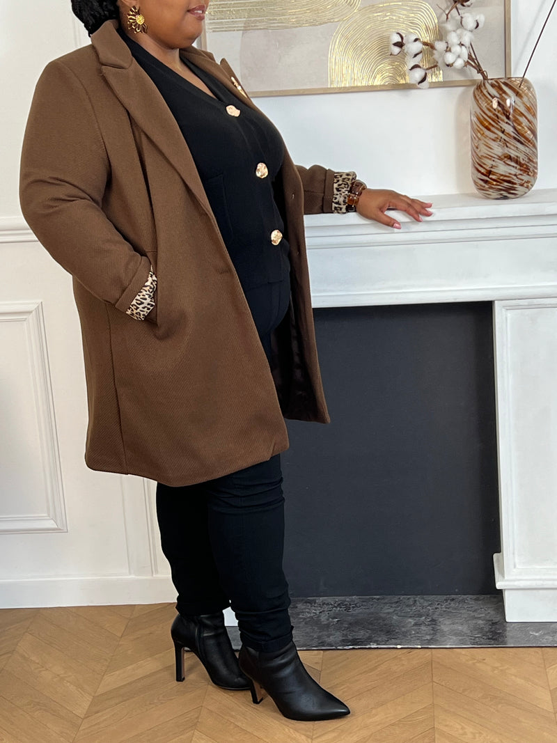Élégant et raffiné, ce manteau mi-long marron séduit par ses détails sophistiqués. Ses manches à revers dévoilent un intérieur léopard chic et audacieux, offrant une touche de caractère subtile. Les boutons dorés amovibles, délicatement travaillés, viennent parfaire l’ensemble avec une note précieuse et intemporelle.