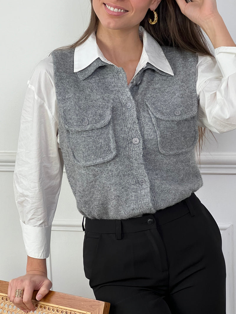 Ajoutez une touche d'élégance à votre look avec ce gilet gris sans manches Marvy. Son col chemise et ses poches lui donnent un style raffiné. Pratique et chic, il s'adapte à toutes les occasions. Un essentiel intemporel pour votre garde-robe !