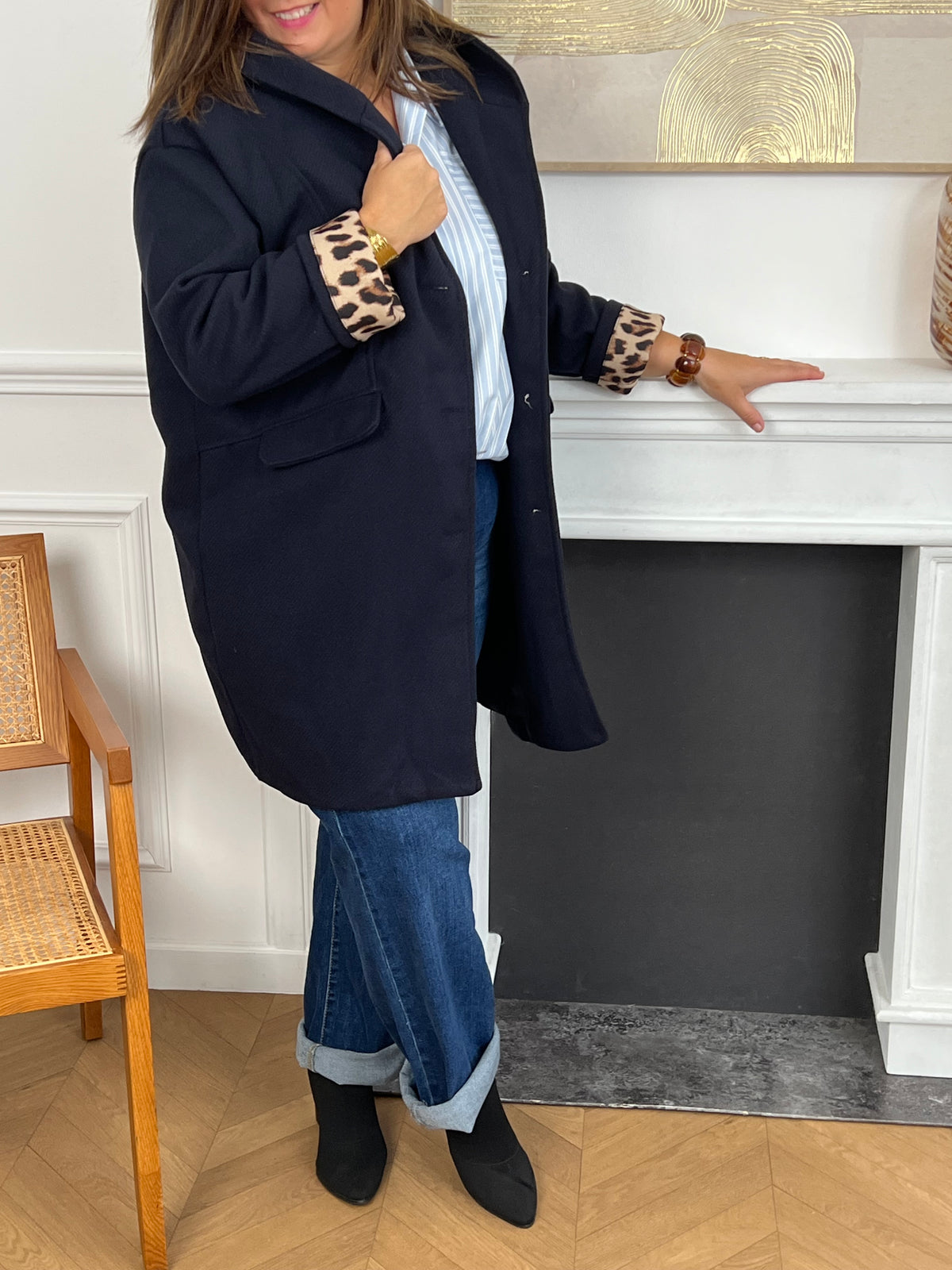 Découvrez notre manteau mi-long bleu marine élégant et tendance, orné de détails léopards sur la capuche et les manches. Pratique et confortable, il dispose de deux poches à l’avant et de boutons sur toute la longueur. Avec sa capuche et son style raffiné, il allie chaleur, originalité et modernité pour un look unique en toute saison.