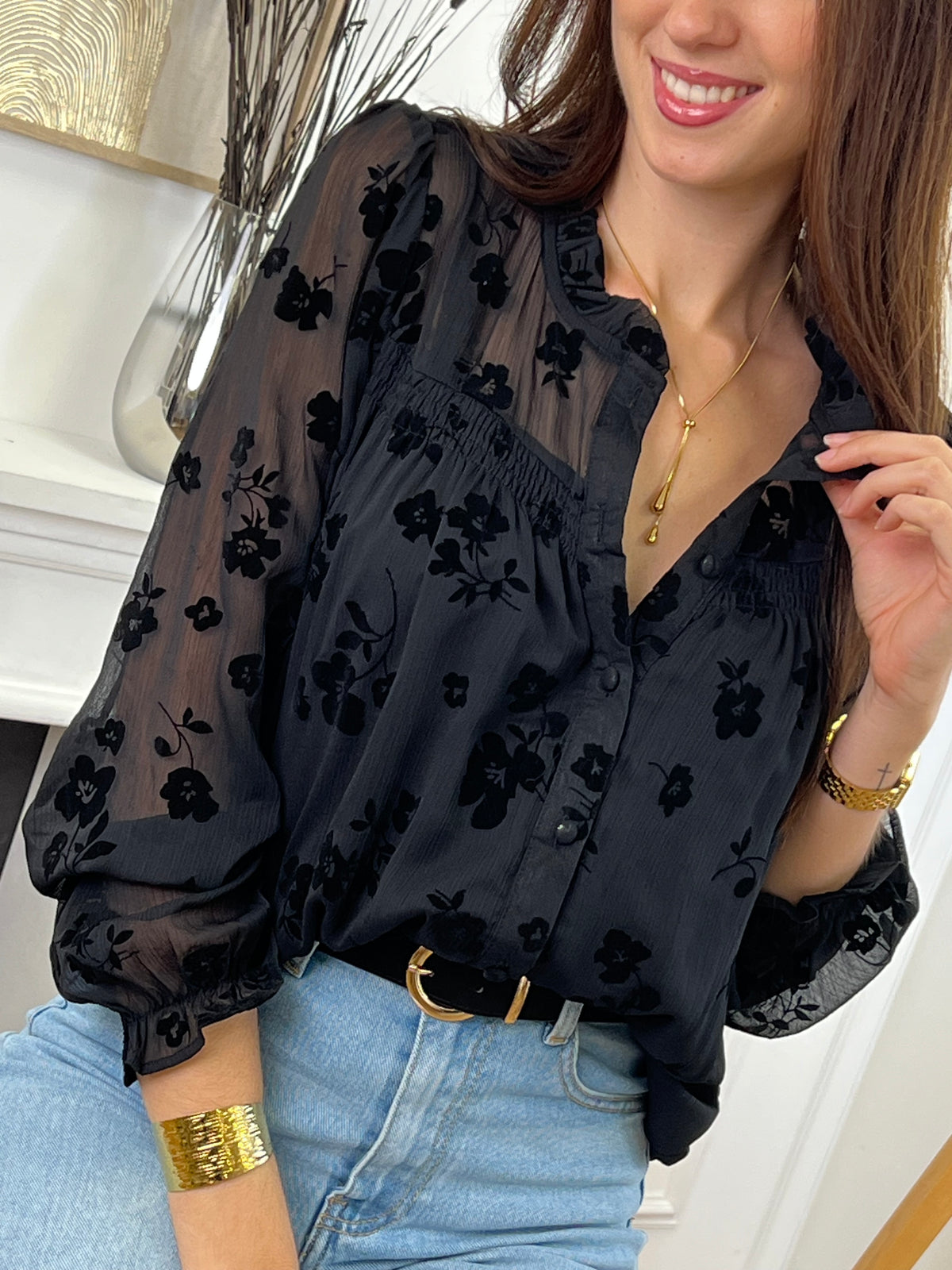 Cette chemise noire à motifs floraux Elenora allie élégance et délicatesse. Ses manches longues et son col rond apportent un charme classique, rehaussé par des volants subtils au col et aux manches.