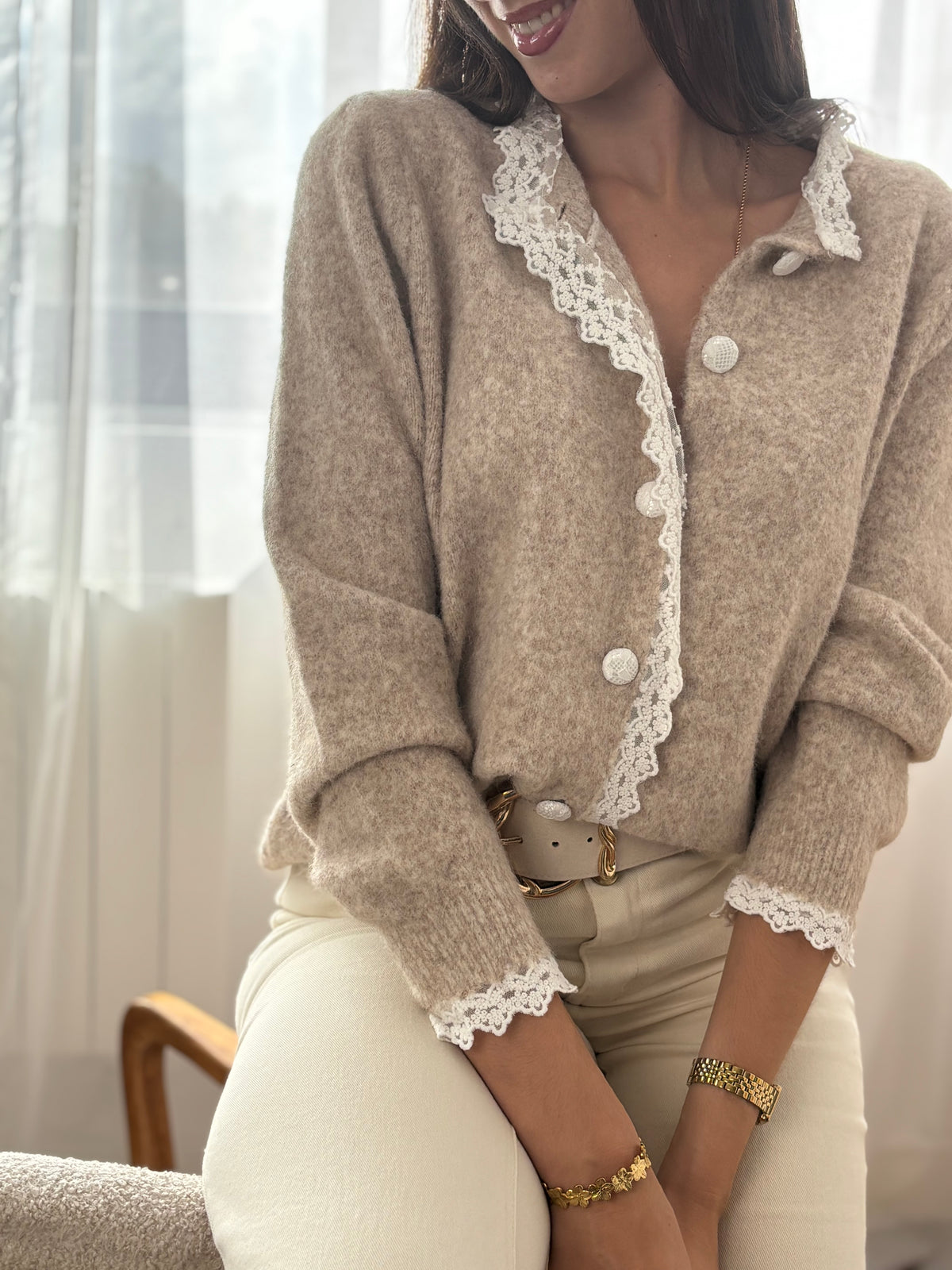 Délicat et élégant, ce pull taupe se distingue par ses détails en broderie écru, subtilement placés au col et le long de la patte de boutonnage. Une touche raffinée qui apporte charme et authenticité à cette pièce intemporelle.