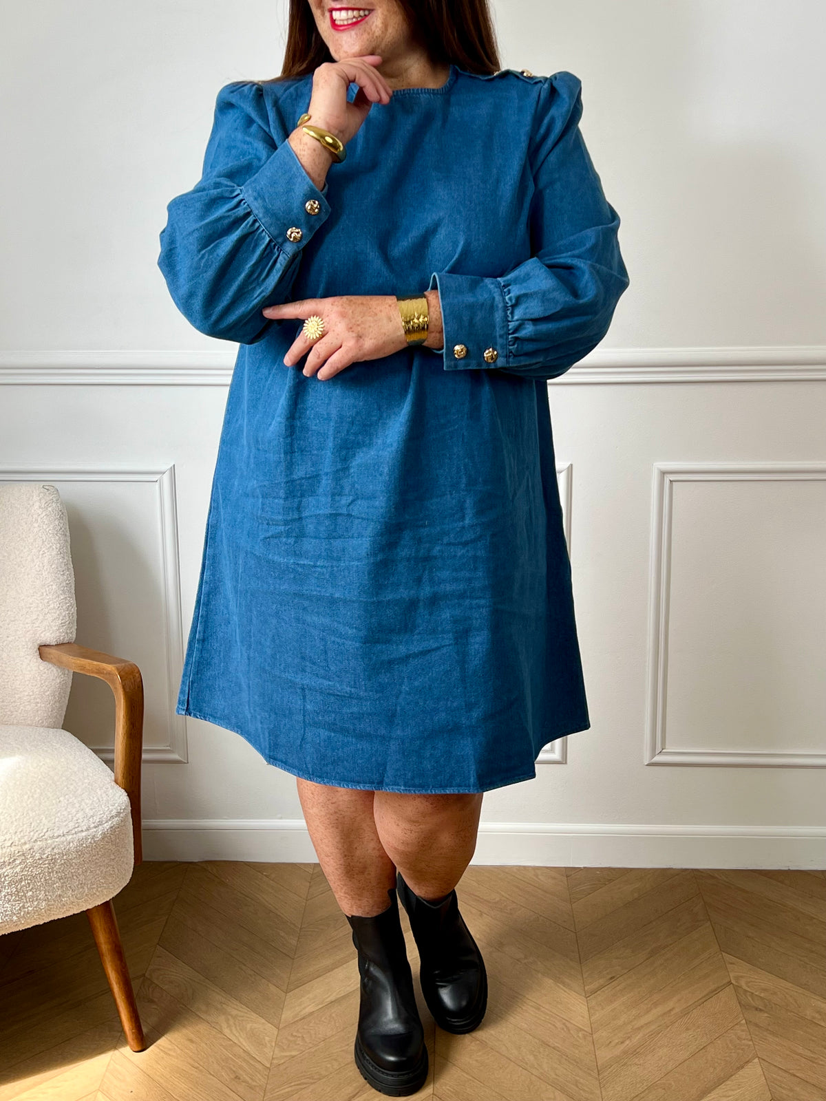 Robe en jean grande taille femme au style casual chic. Col rond et coupe droite moderne, idéale au quotidien comme en sortie. Détails raffinés : boutons dorés aux poignets et à l’épaule. Bleu intemporel, 100% coton pour allier confort et élégance.
