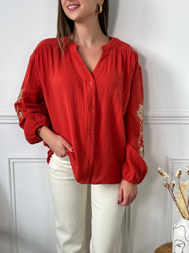 Découvrez la chemise Analys orange à motifs dorés ! Légère et élégante avec ses manches longues et son col rond, elle est rehaussée de broderies florales dorées pour un look raffiné. Boutonnée sur la longueur , elle apportera une touche de sophistication à vos tenues.